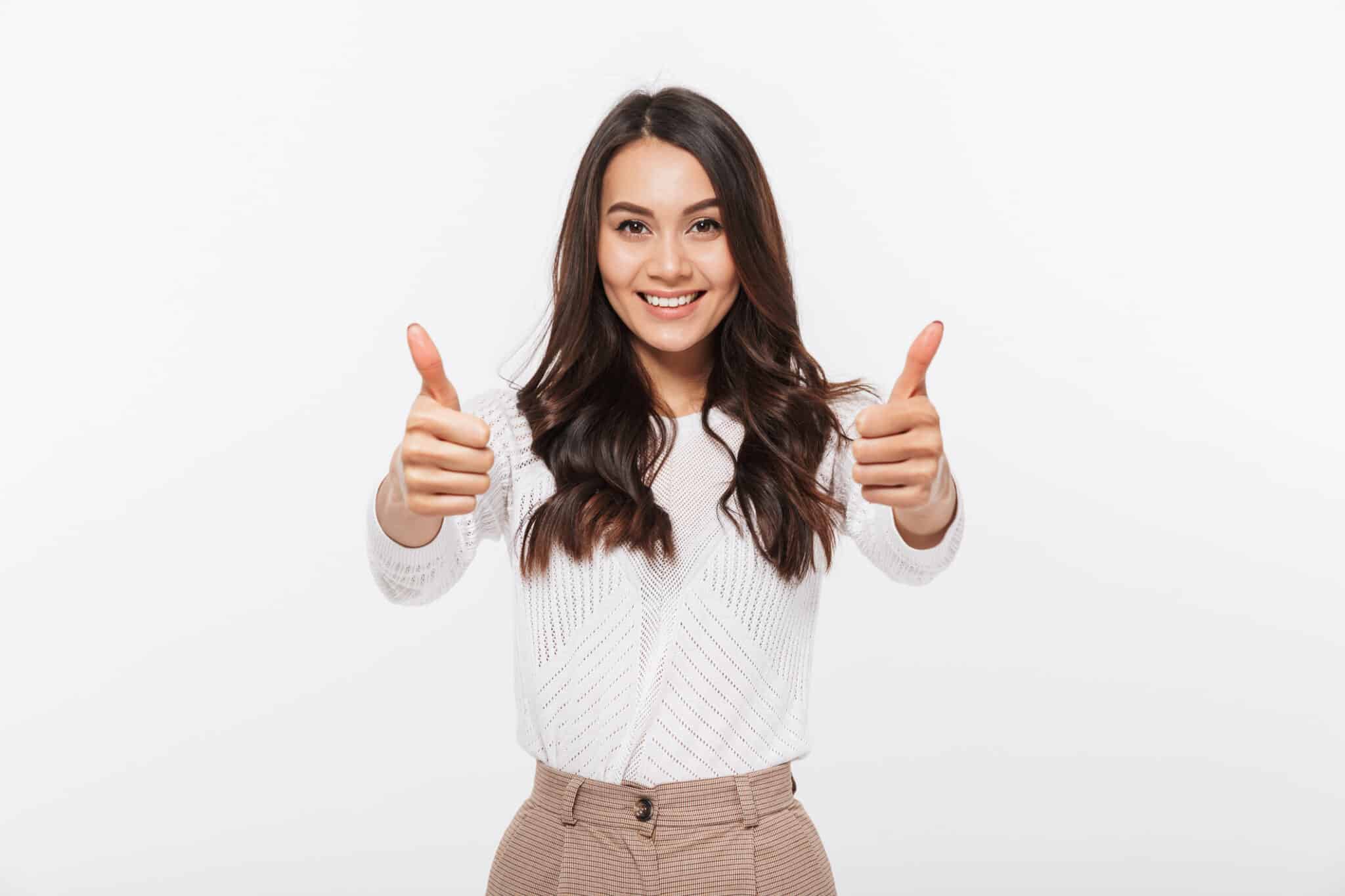 A woman smiling and showing a thumbs up for choosing the right emergency heating and AC repair service, isolated over a white background.