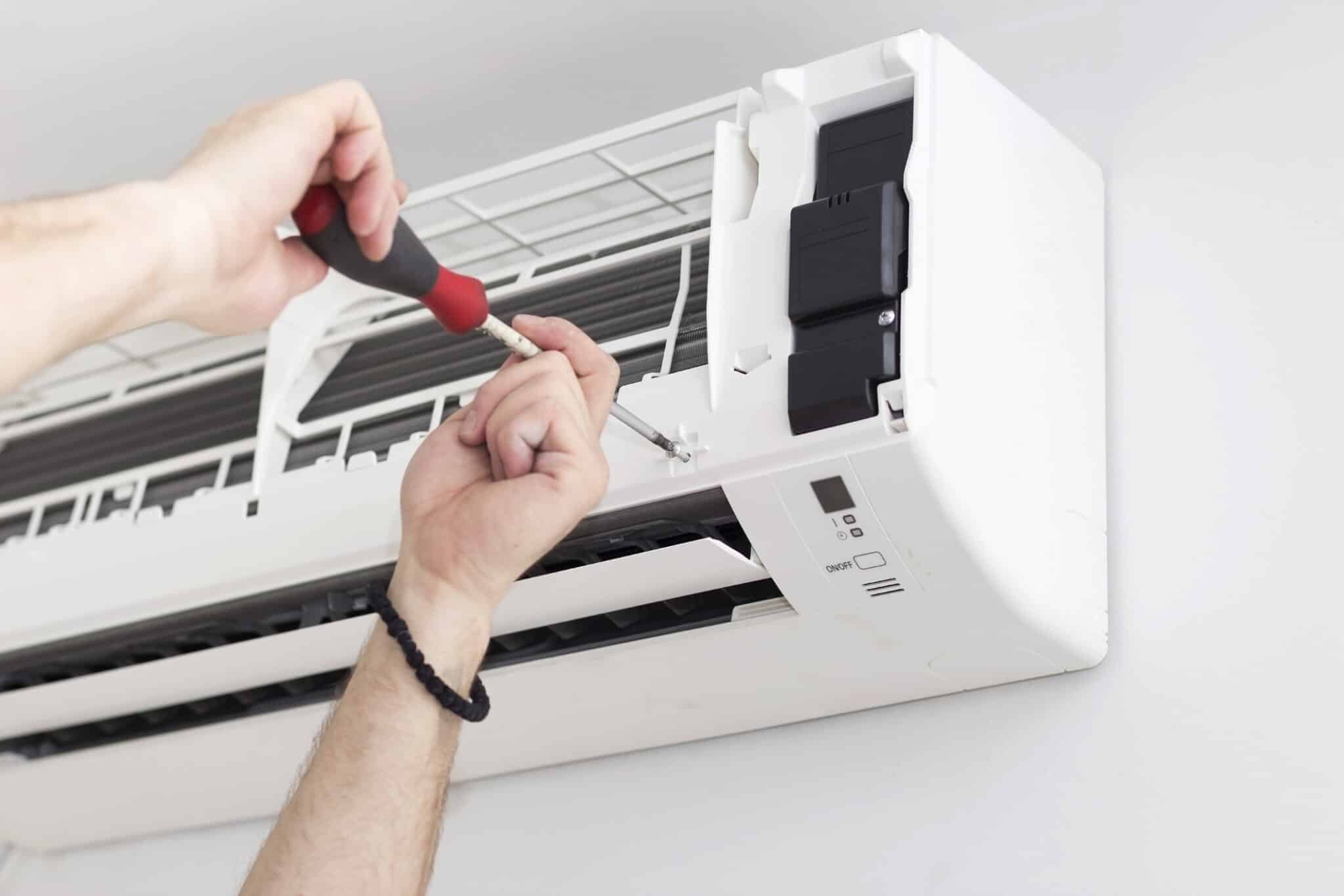 A man installing an air conditioner in an apartment. Air Conditioner Installation by One Hour Heating & Air Conditioning of San Diego