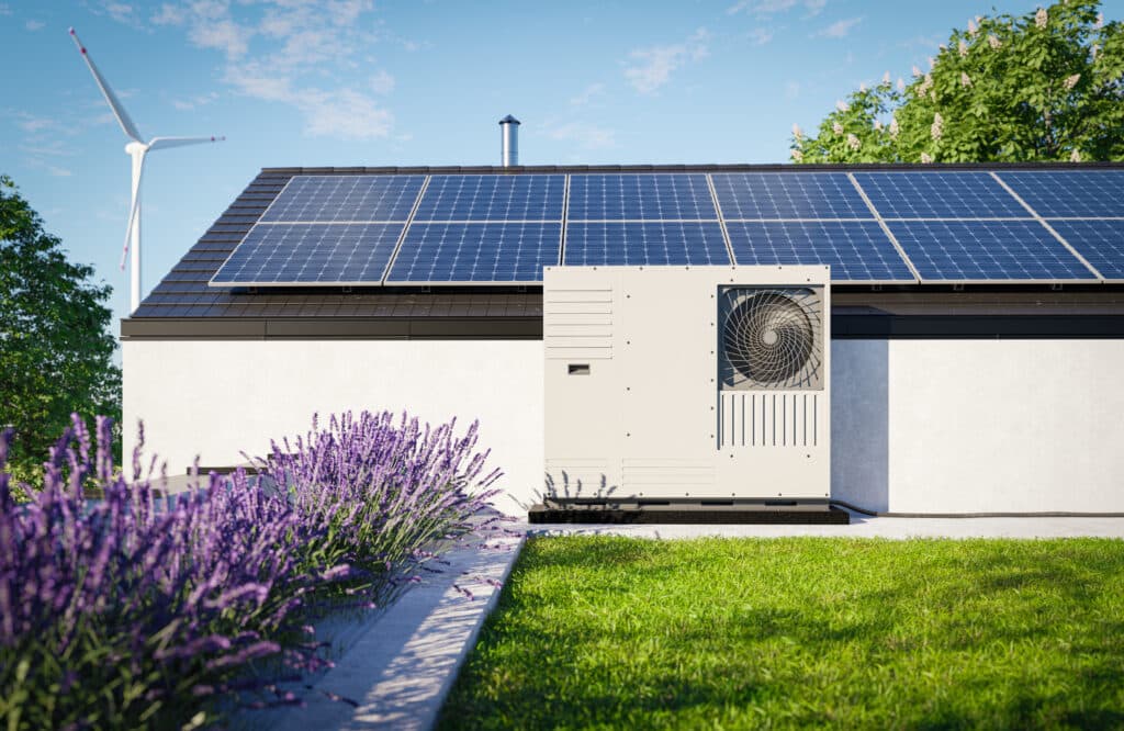 A heat pump with photovoltaic panels installed on the roof of a single-family house, along with a green roof covered in grass over the garage, forms an eco-friendly HVAC solution for the property.